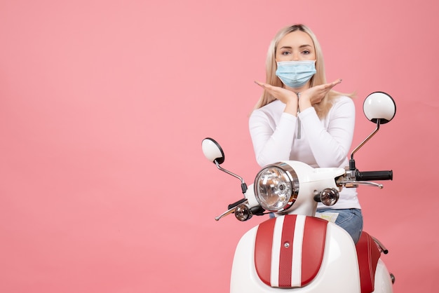 Front view young lady with medical mask standing near moped