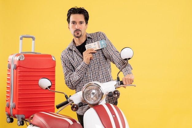 Front view young male around bike holding ticket on yellow background road trip ride motorcycle voyage