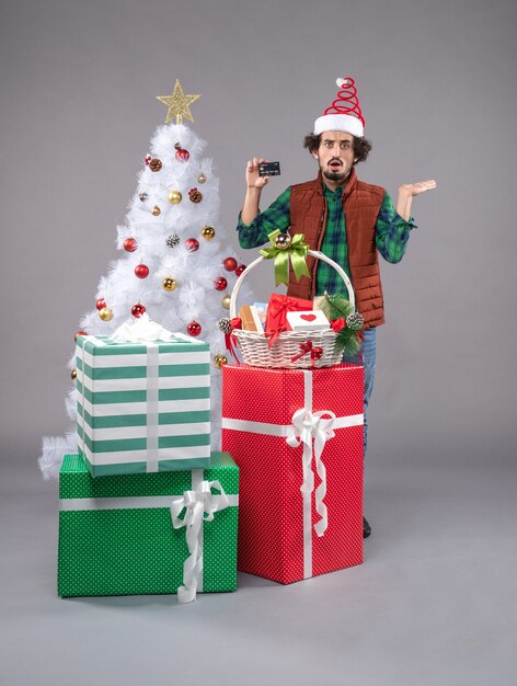 Front view young male around holiday presents on the grey 