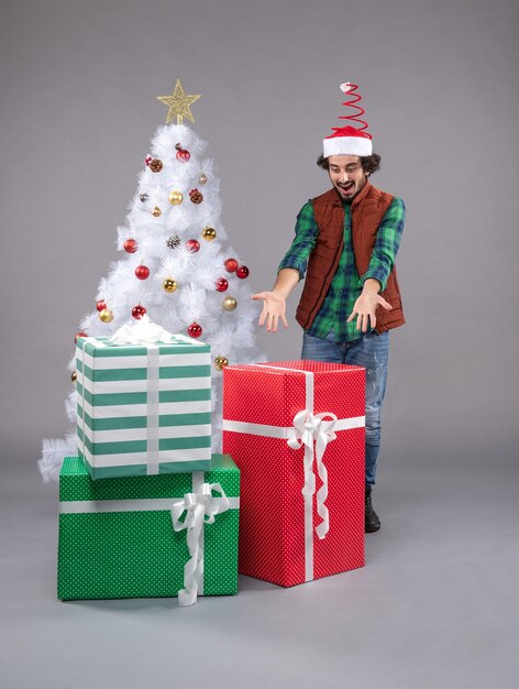 Front view young male around holiday presents on the grey 