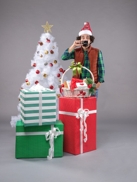 Front view young male around holiday presents on light desk new year xmas human