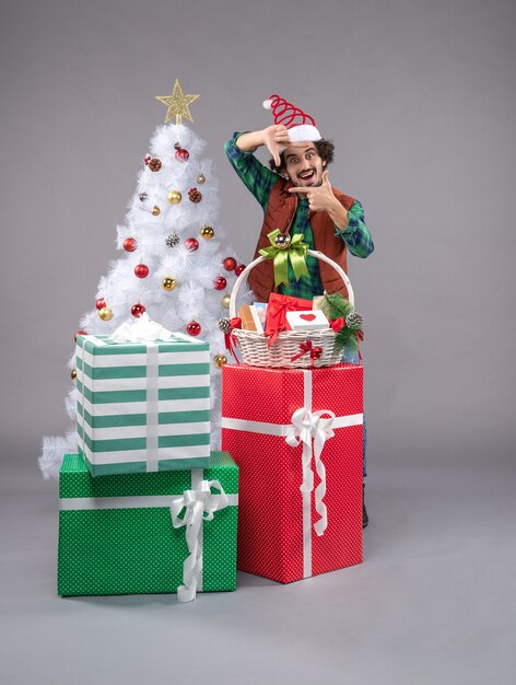 Front view young male around holiday presents on light