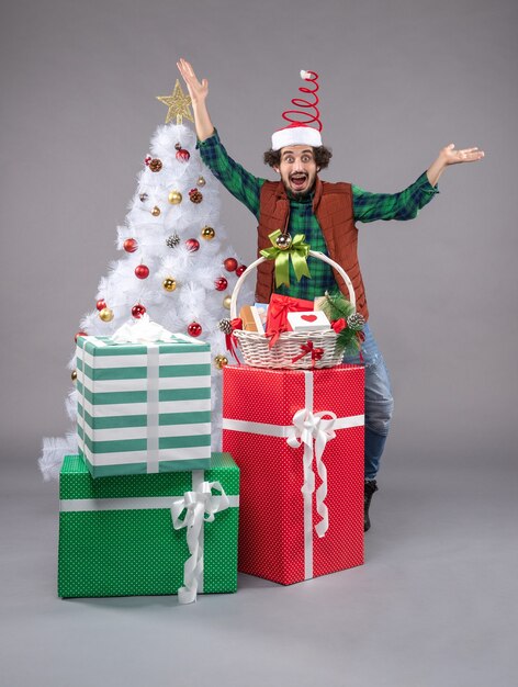 Front view young male around holiday presents on light