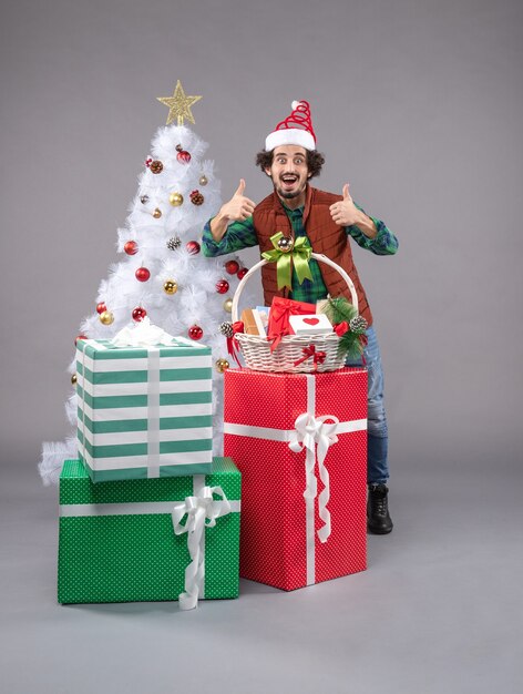 Front view young male around holiday presents on light