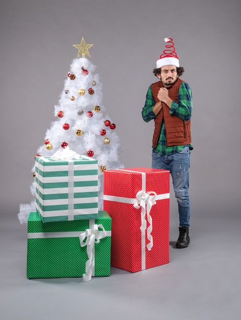 Вид спереди молодой самец вокруг праздничных подарков на свету