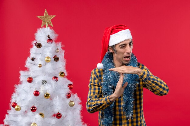 Front view young male around new year atmosphere on a red wall emotions holiday christmas