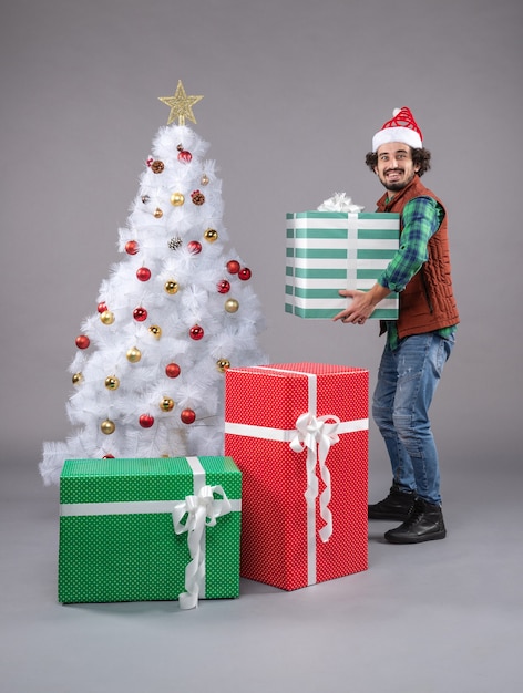 Free photo front view young male around presents on a grey