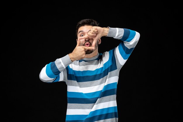 Free photo front view young male in blue striped jersey doing frame gesture with both hands