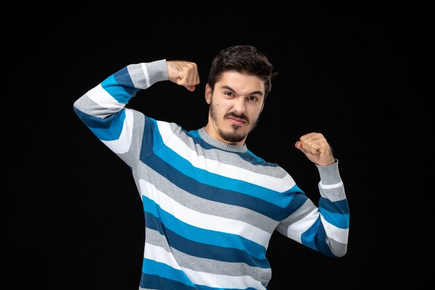 Front view young male in blue striped jersey flexing