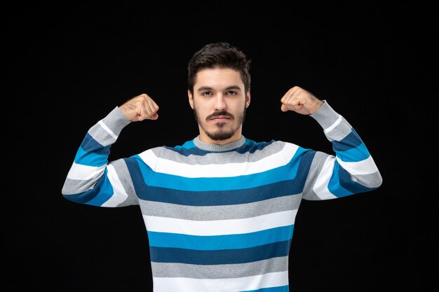 Front view young male in blue striped jersey flexing