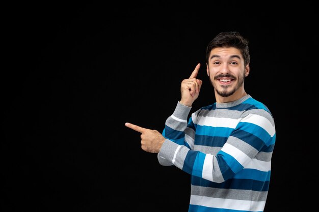 Front view young male in blue striped jersey pointing at copy space