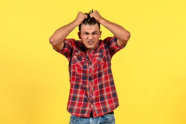 Front view young male in bright shirt just standing on a yellow background color male model