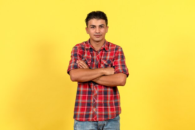 Front view young male in bright shirt just standing on yellow background color male model