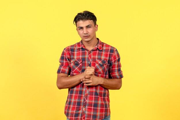 黄色の背景の男性モデルの色に明るいシャツを着た若い男性の正面図