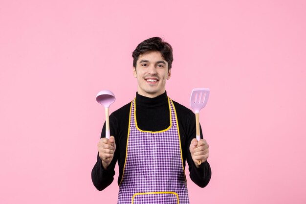 분홍색 배경색 음식 요리 직업 균일한 수평 반죽 요리에 숟가락을 얹은 망토를 입은 젊은 남성