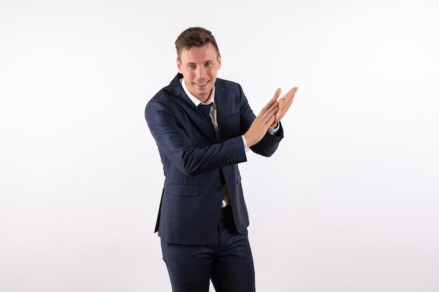 Front view young male clapping in classic strict suit on white background emotions human male suit fashion model