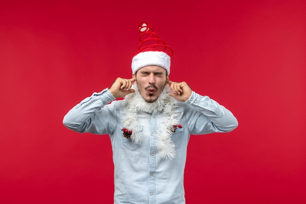 Free photo front view young male closing his ears, holiday christmas red