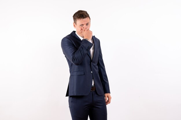 Front view young male closing his nose in classic suit on white background emotion costume fashion model human male