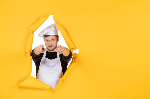 Foto gratuita vista frontale giovane cuoco maschio in mantello bianco e berretto su sfondo giallo cibo lavoro uomo bianco cucina foto colori cucina