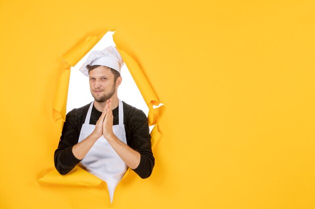 Front view young male cook in white cape and cap on yellow background food white man cuisine photo color kitchen job