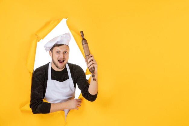 노란색 배경 음식 백인 요리 사진 컬러 주방 일에 롤링 핀을 들고 흰색 케이프에서 전면 보기 젊은 남성 요리사