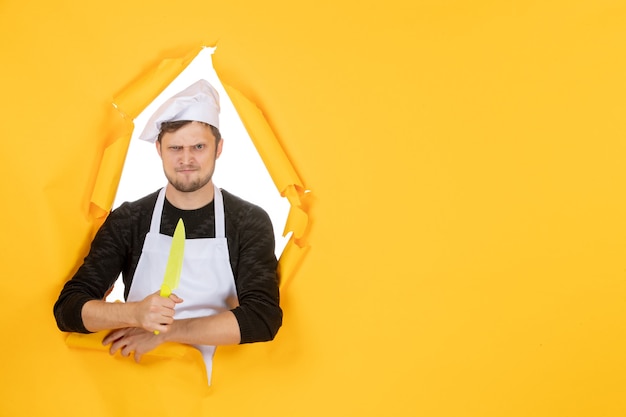 正面図黄色の背景に白いマントで若い男性料理人白い色のキッチン料理仕事人の写真