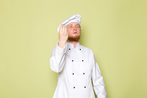 Вид спереди молодой мужской повар в белом костюме повара белая шапка вкусный знак