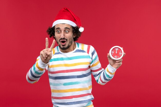 Front view young male counting showing number on red wall red time new year holiday