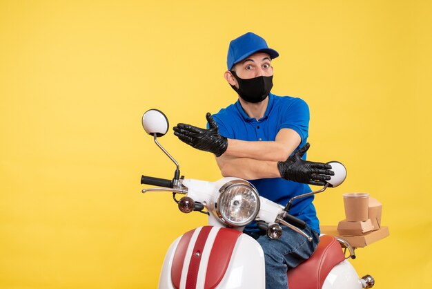 노란색 배경 covid- 대유행 배달 서비스 작업 바이러스 자전거 작업에 파란색 유니폼에 전면보기 젊은 남성 택배