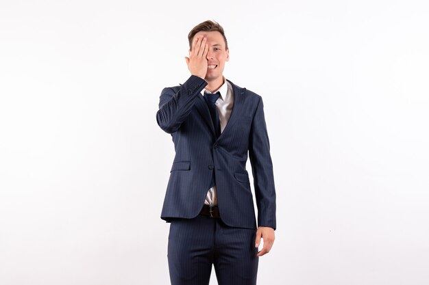 Front view young male covering half of his face in classic strict suit on white background male fashion model business emotions
