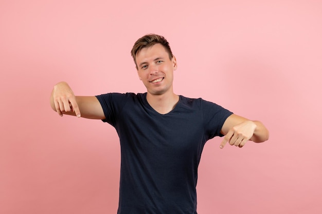 Free photo front view young male in dark-blue shirt smiling on pink background