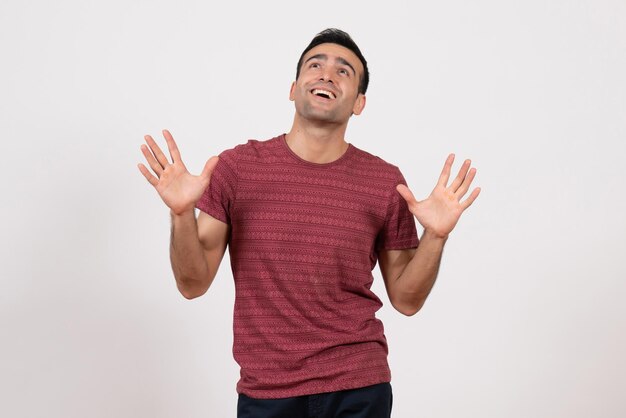 Front view young male in dark-red t-shirt posing on light-white background