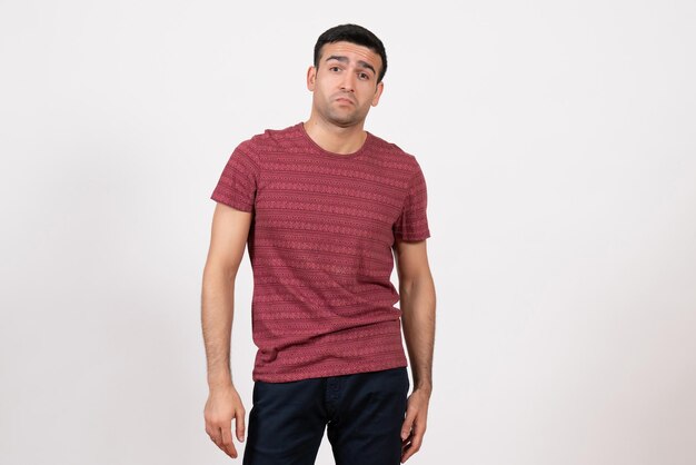 Front view young male in dark-red t-shirt posing on a white background