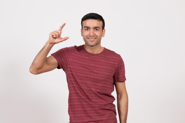 Front view young male in dark-red t-shirt posing on white background