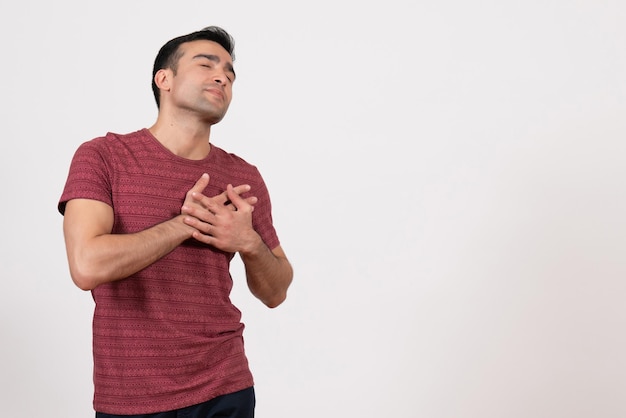 Front view young male in dark-red t-shirt posing on white background