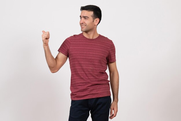 Front view young male in dark-red t-shirt standing smiling on white background