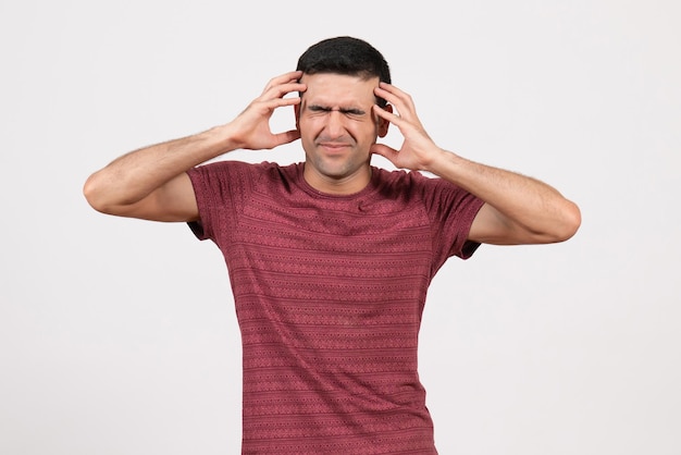 Front view young male in dark-red t-shirt standing on a white background