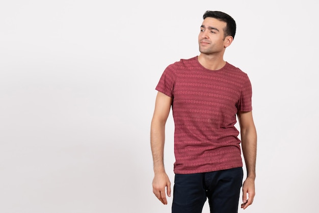 Front view young male in dark-red t-shirt standing on the white background