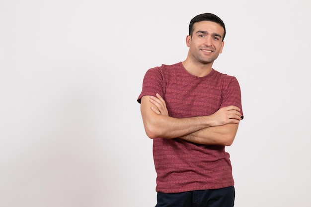 Front view young male in dark-red t-shirt standing on white background