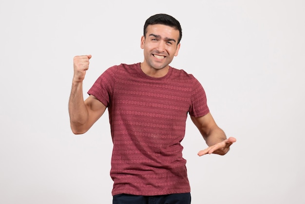 Front view young male in dark-red t-shirt standing on white background