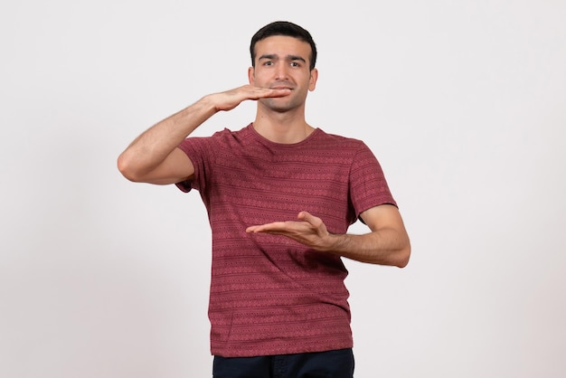 Front view young male in dark-red t-shirt standing on white background