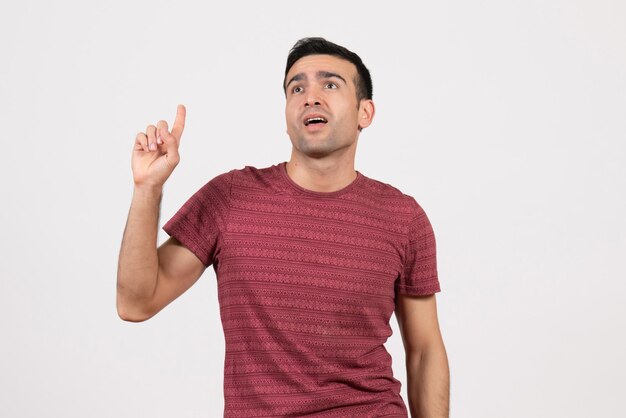 Front view young male in dark-red t-shirt standing on white background