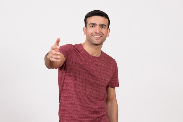 Front view young male in dark-red t-shirt standing on white background