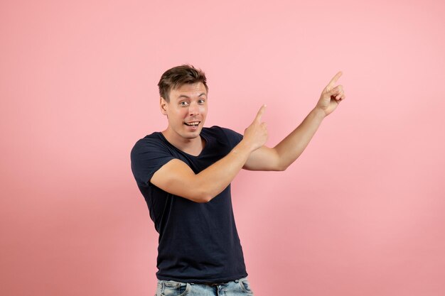 Front view young male in dark t-shirt posing on light pink background