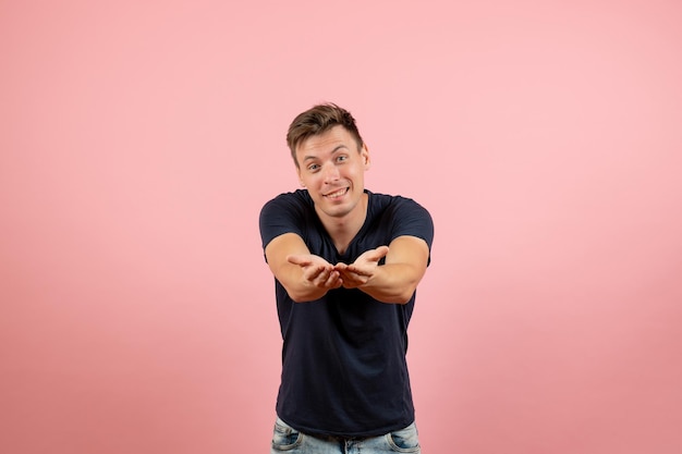 Free photo front view young male in dark t-shirt posing on pink desk