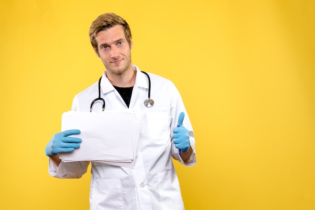 Front view young male doctor holding analyzes on yellow background hospital health medic
