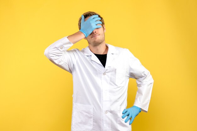 正面図黄色の背景に強調された若い男性医師人間の薬のパンデミック