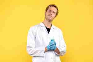 Free photo front view young male doctor on yellow background human covid medic pandemic