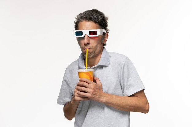 Front view young male drinking soda and watching movie in d sunglasses on a white surface