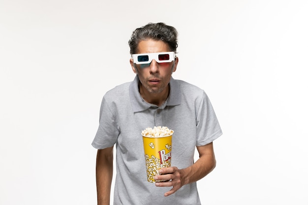 Front view young male eating popcorn in d sunglasses on white desk